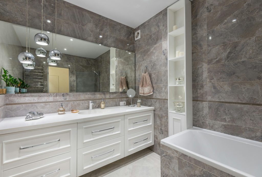 Contemporary bathroom with marble tiles, spacious vanity, and elegant fixtures.